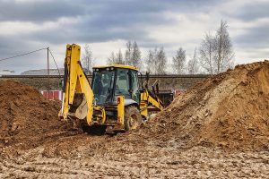 Excavator digging in soil at construction site for environmental project.