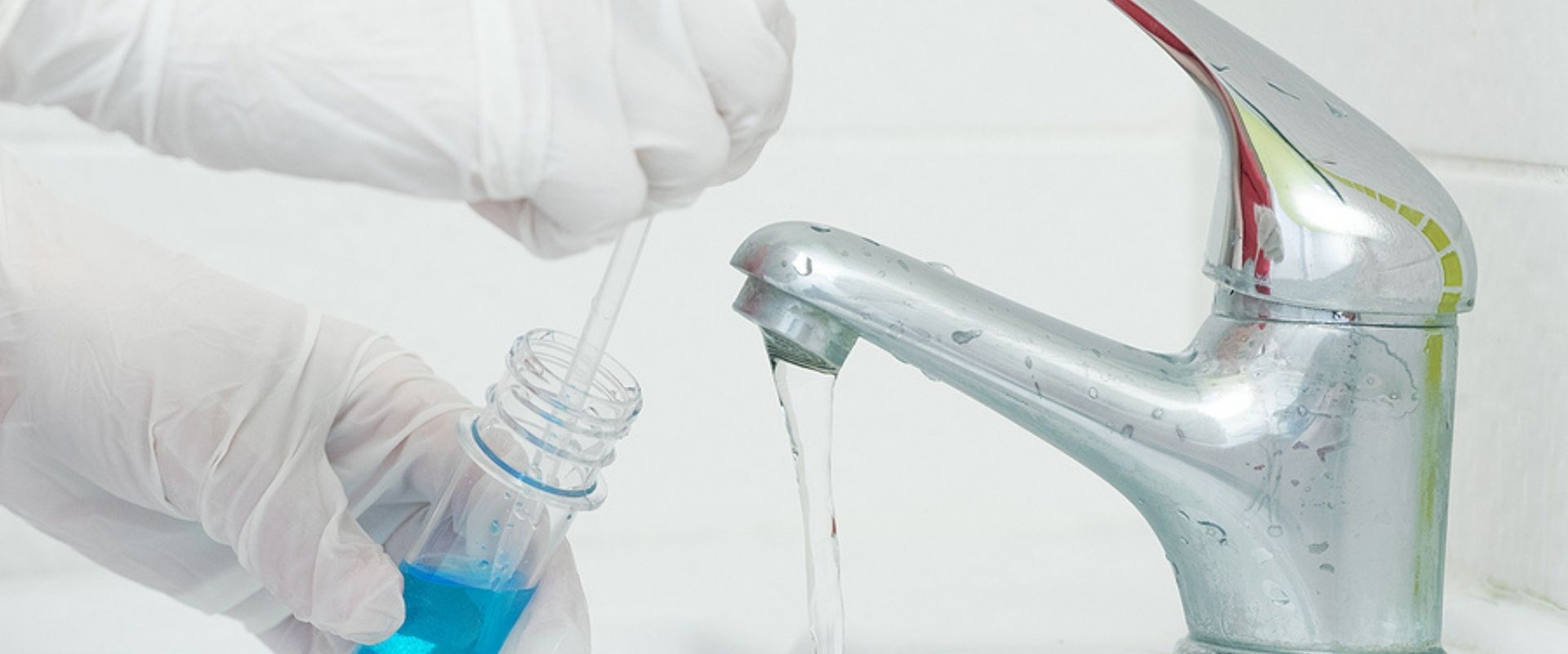 Someone taking a sample of tap water to test and identify contaminants in it.