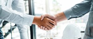 Environmental consultant and engineer shaking hands at a project meeting.