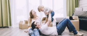 A man, woman, and child playing on a floor at home