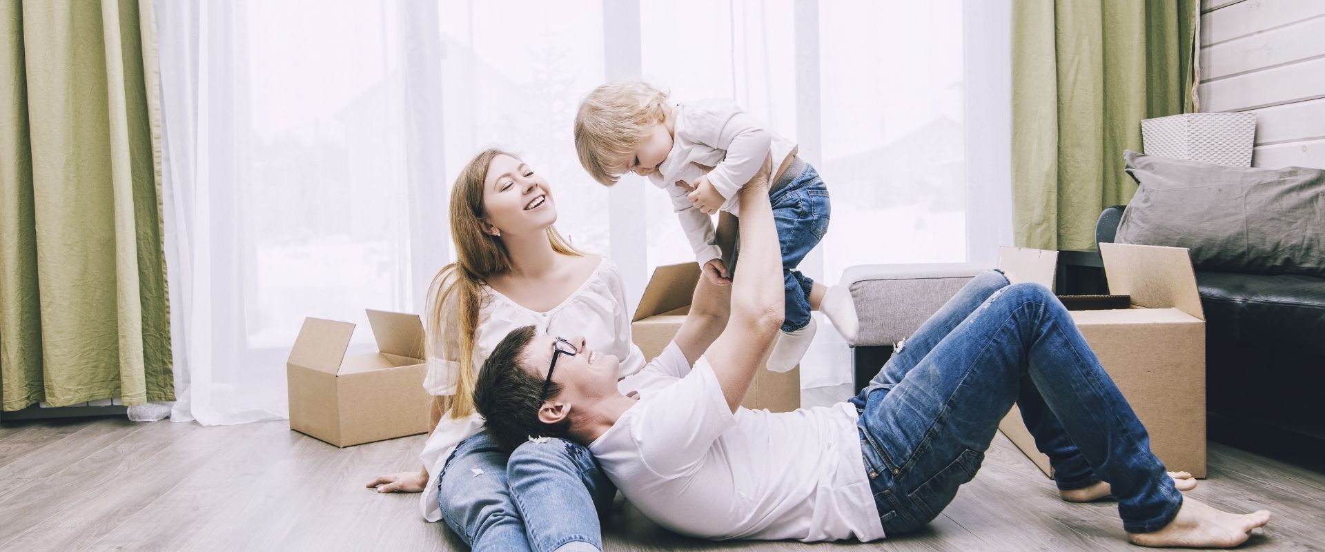 A man, woman, and child playing on a floor at home