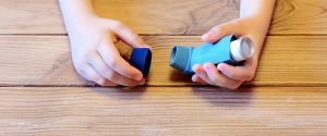 A child's hands and inhaler