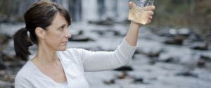 An expert looking at a water sample they just took to test
