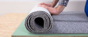 A man rolling out a new carpet